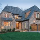 Cozy two-story house with blue roof and autumn leaves.