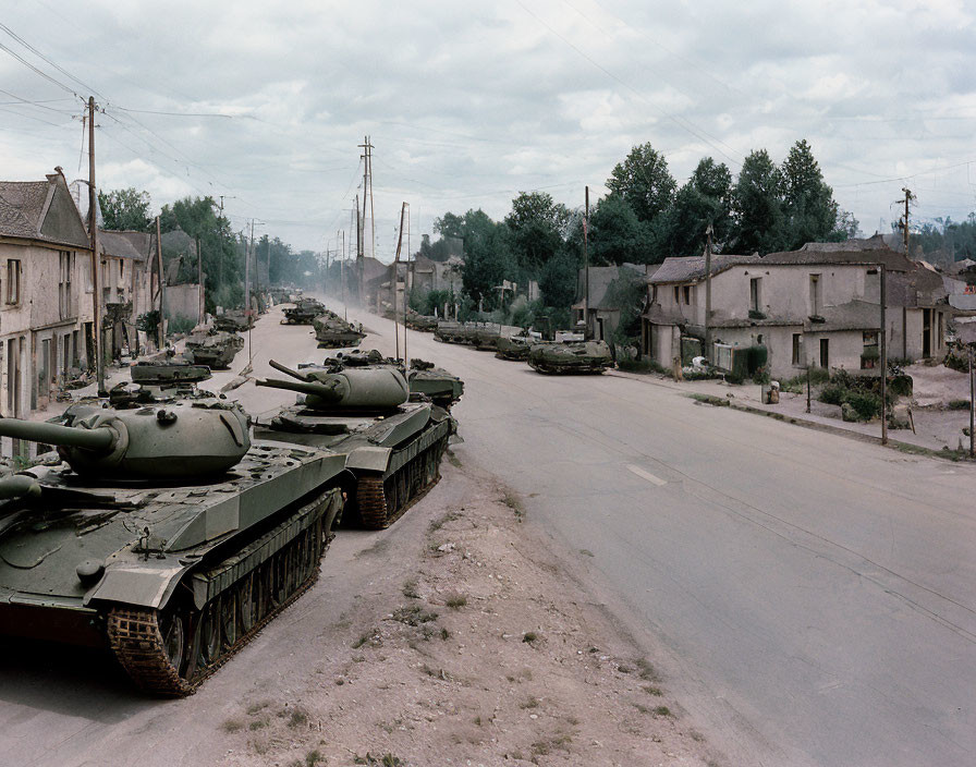 Military tanks in desolate, ruined town under overcast sky