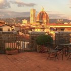 Balcony view of old cityscape at sunset with golden-domed buildings and breakfast spread