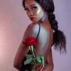 Young girl with gentle smile and red flower in hair against soft-lit backdrop