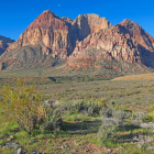 Colorful desert landscape with towering cliffs and sand dunes.