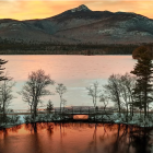 Serene Sunrise Scene: Lake, Trees, Hills, and Fog