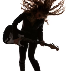 Silhouette of Woman Playing Electric Guitar in Warm Colors