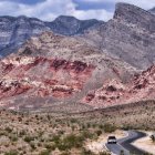 Scenic desert landscape with red and grey rock formations under cloudy sky