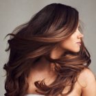 Portrait of a Woman with Wavy Brown Hair and Colorful Flowers