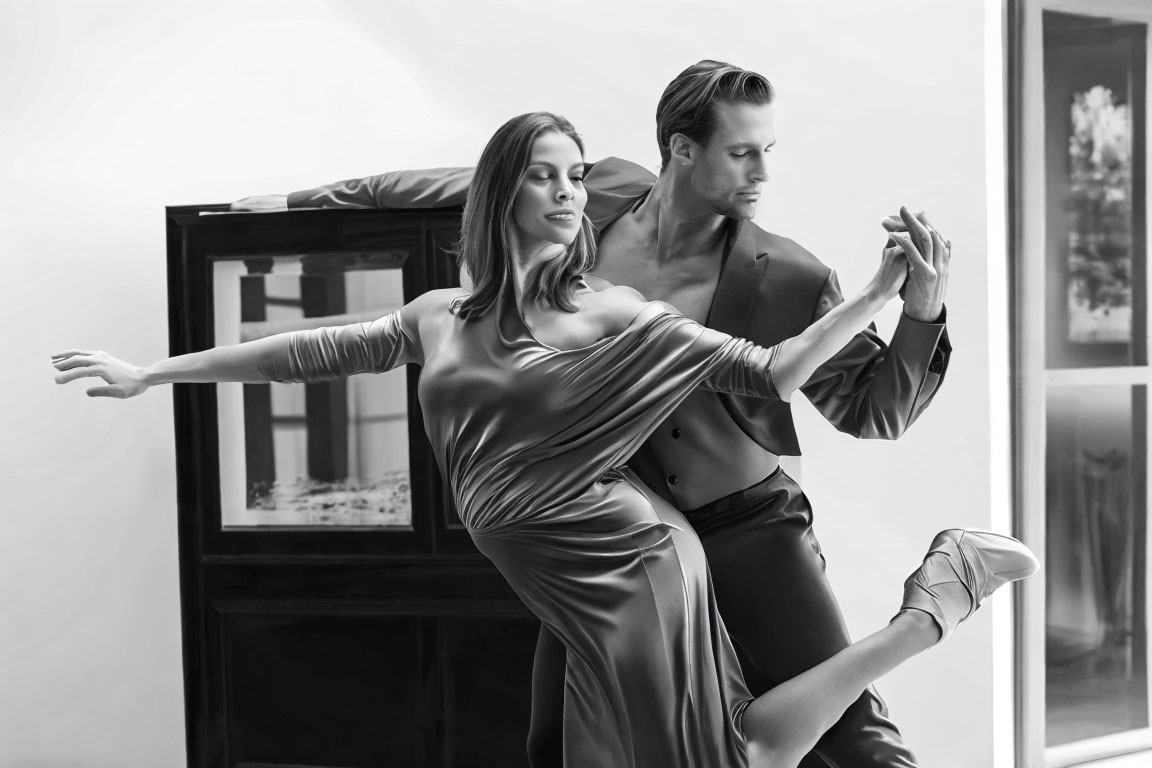 Monochrome image: Couple in poised dance move, man holding woman's hand