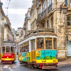Vibrant village scene: colorful trams, artful buildings, cobblestone street