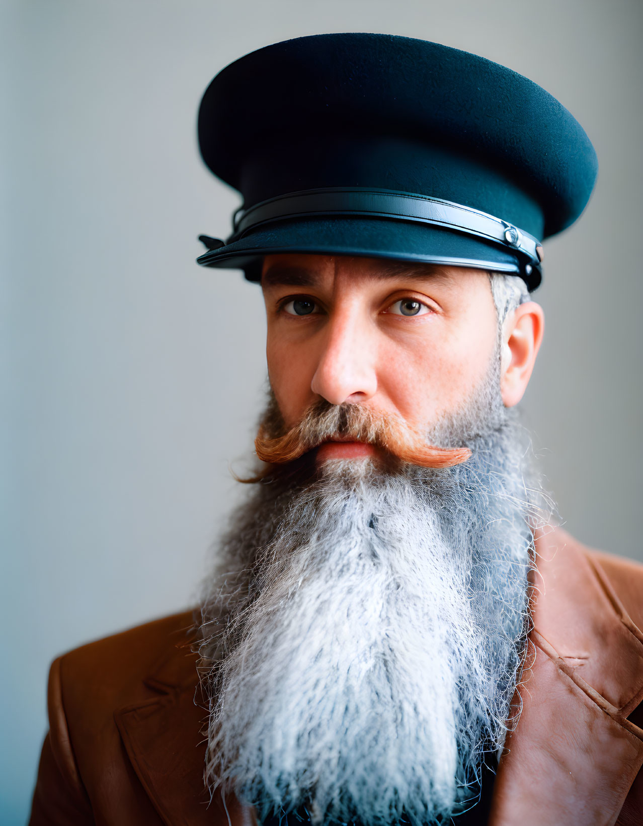 Man with Styled Mustache and Long Beard Wearing Beret in Serious Expression