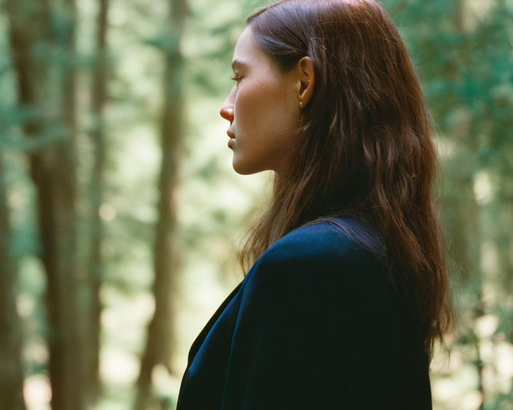 Woman with Long Hair in Forest, Sunlight Filtering, Wearing Dark Coat