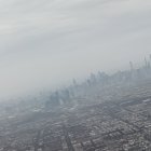 Sunlit skyscrapers in dense cityscape under hazy skyline