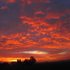 Colorful sunset painting of layered hills and clouds.