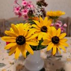 Yellow and Purple Flowers in Glass Vase on Textured Background