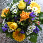 Assorted vibrant flowers: roses, daisies, lilies on green foliage