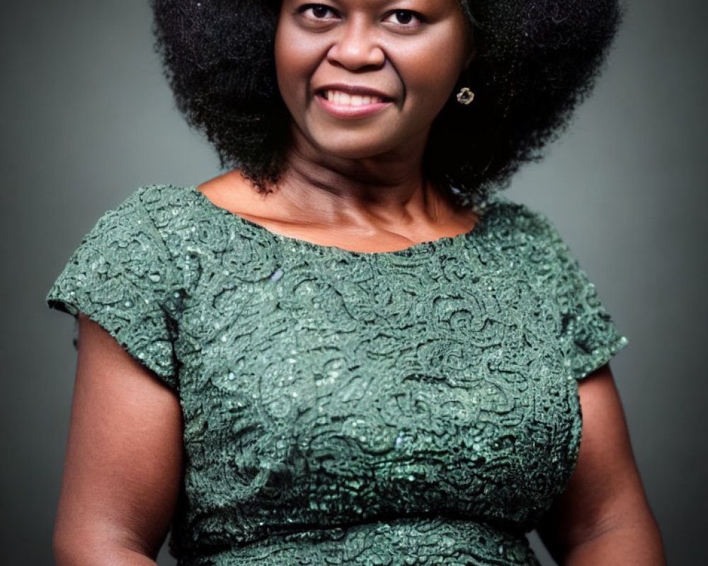 Smiling woman with voluminous afro in green lace dress