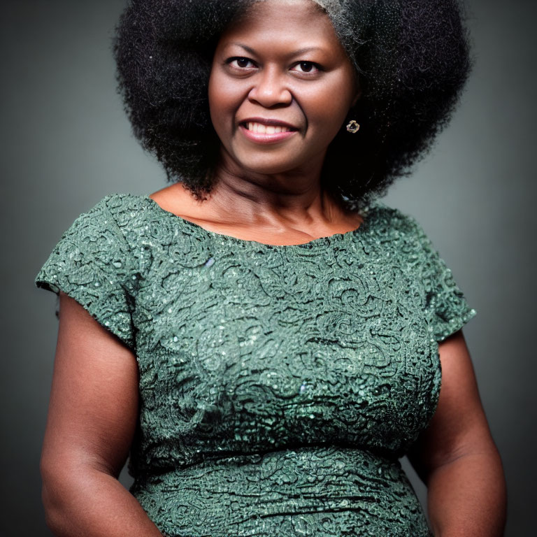 Smiling woman with voluminous afro in green lace dress