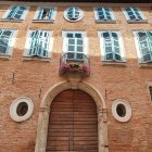 European Stone Building with Wooden Arched Door & Blue Windows