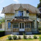 Yellow Two-Story House with Gable Roof and Front Porch