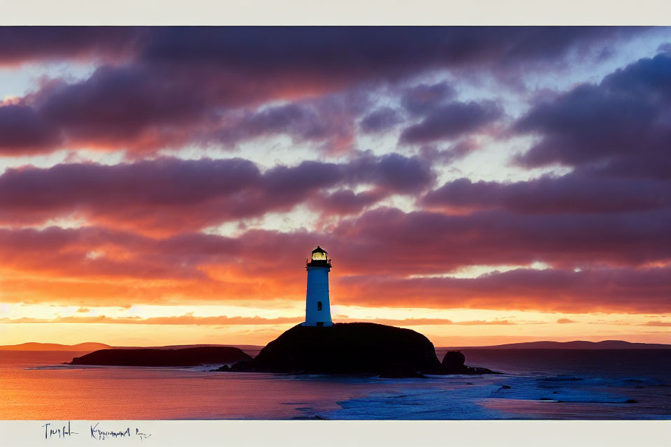 Vibrant orange and red sunset behind a solitary coastal lighthouse