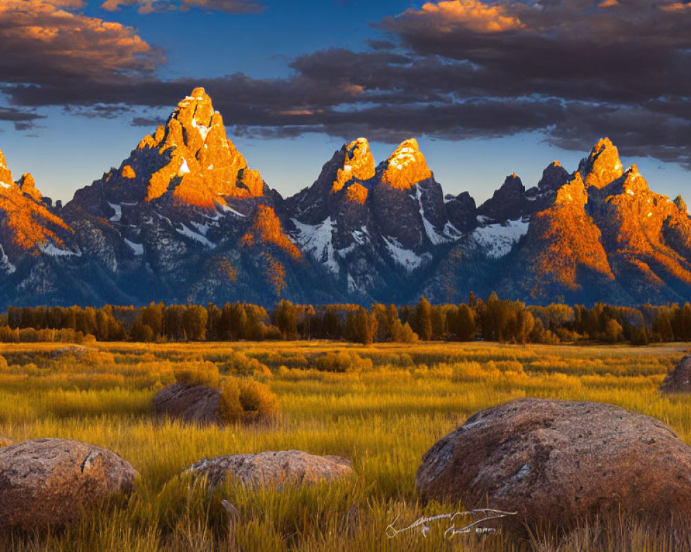 Scenic sunset over rugged mountain peaks and field with boulders