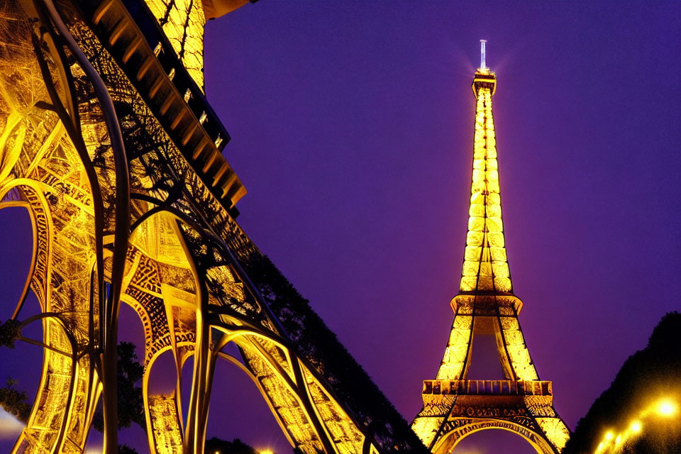 Eiffel Tower illuminated at night with golden lights against dusk sky