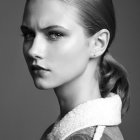 Monochromatic portrait of woman with gold jewelry and braided hairstyle