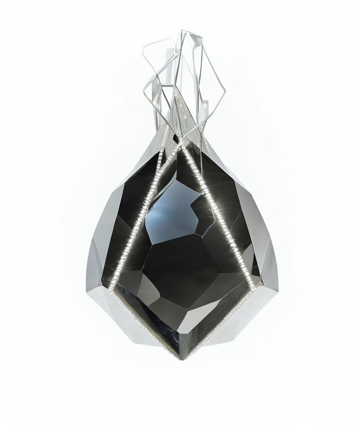 Faceted shiny black crystal with metallic structure on white background