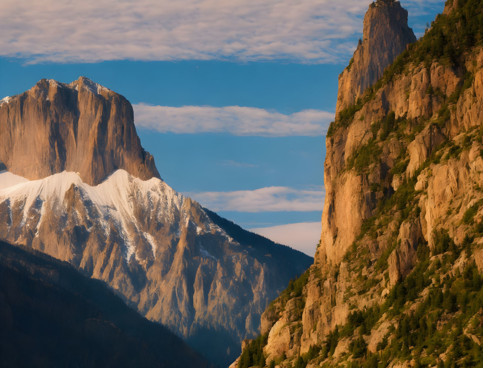 Majestic mountain peaks in golden sunlight against a blue sky