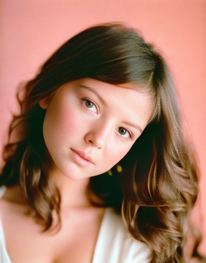 Young Girl with Wavy Hair on Pink Background in White Top