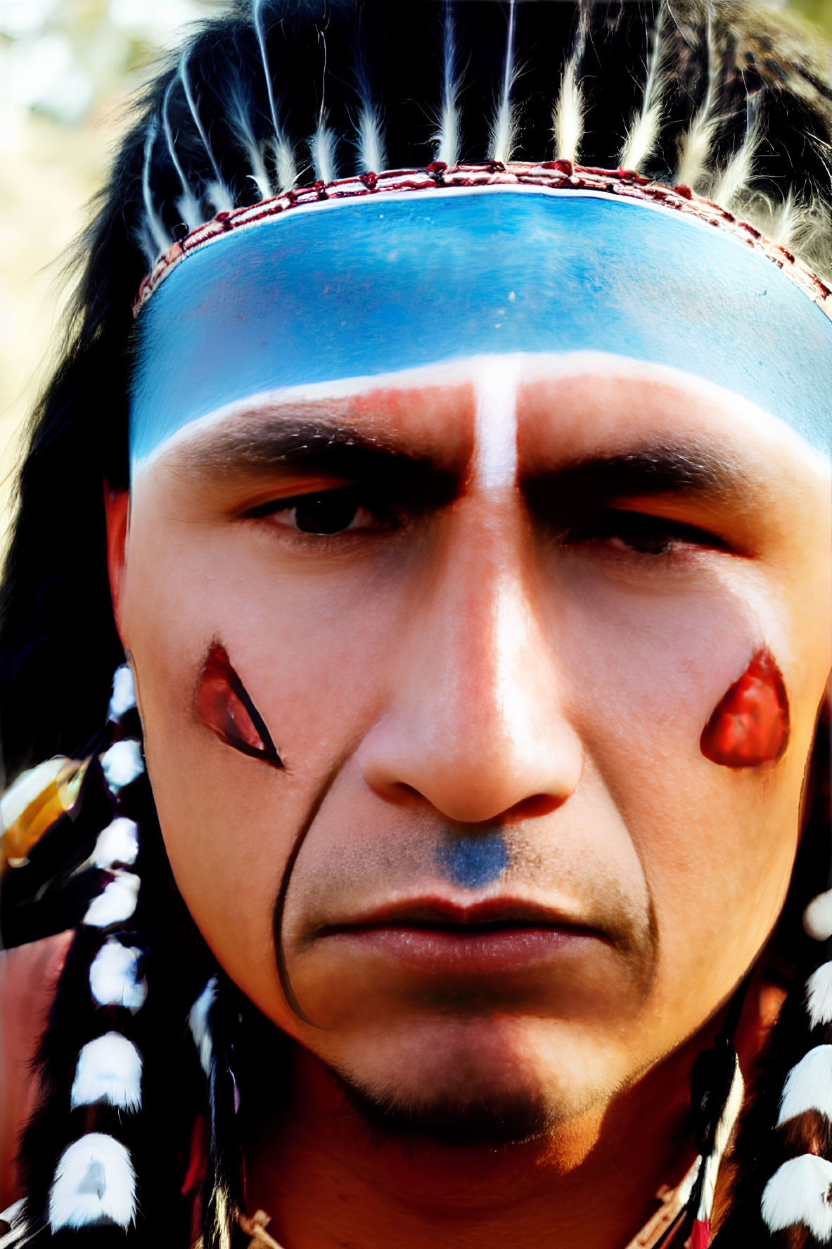 Person in Feather Headdress and Face Paint with Solemn Expression