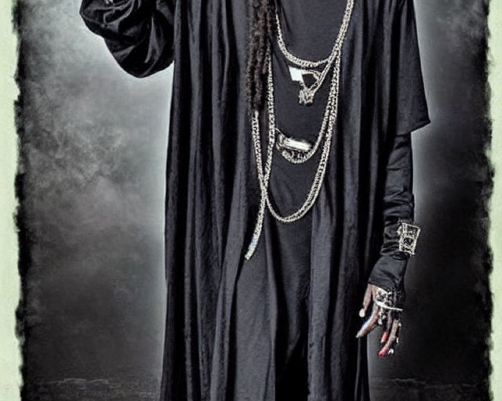 Person with long black dreadlocks in black robe rings bell in front of dark backdrop