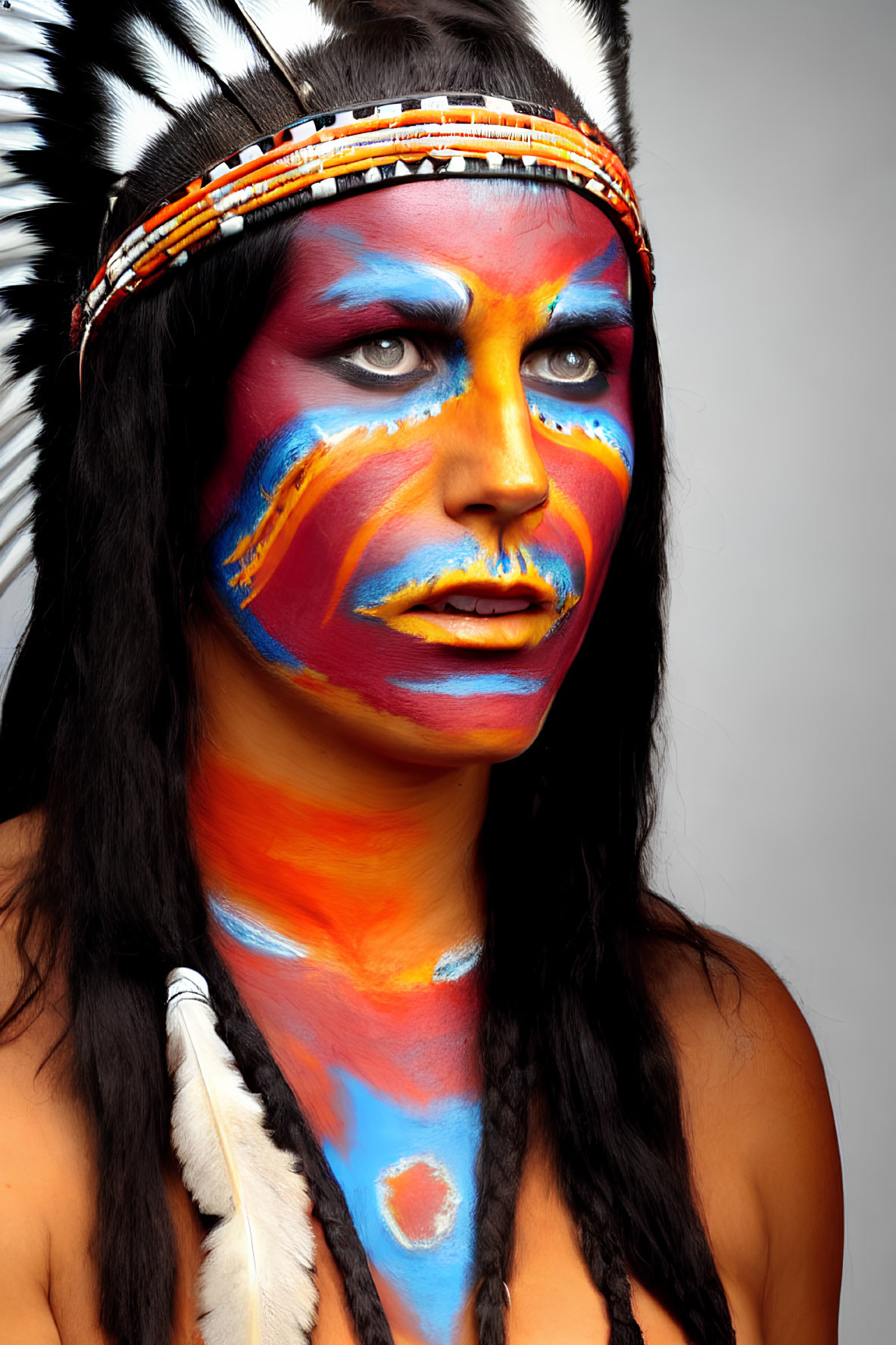 Vibrant face paint in blue, orange, and yellow with Native American headdress.