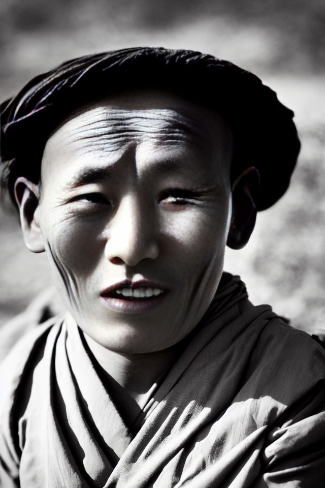 Portrait of person with headscarf, selective color, calm expression, subtle smile