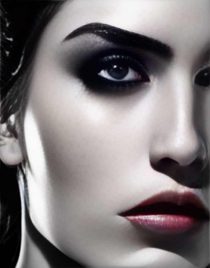 Detailed close-up of woman with dramatic makeup: dark eyebrows, intense eyes, red lips.