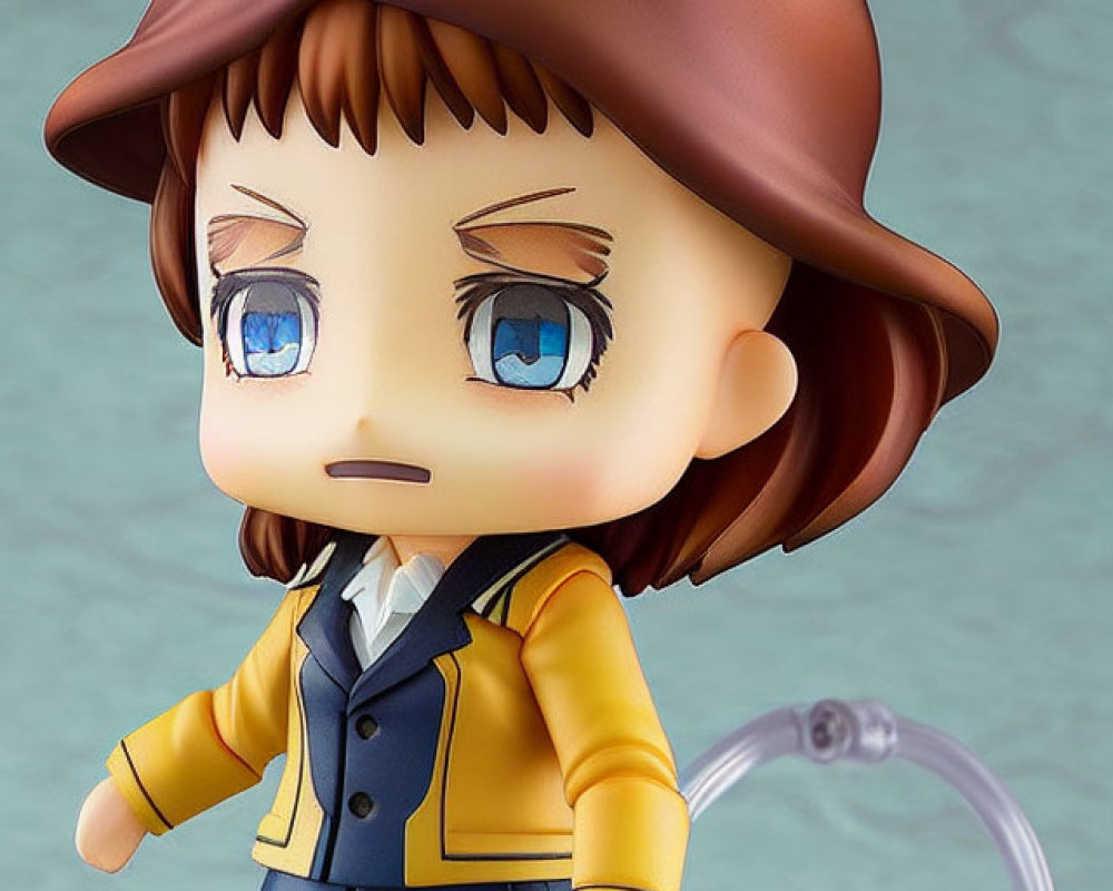 Brown-haired chibi figurine in yellow jacket, blue pants, holding black baton