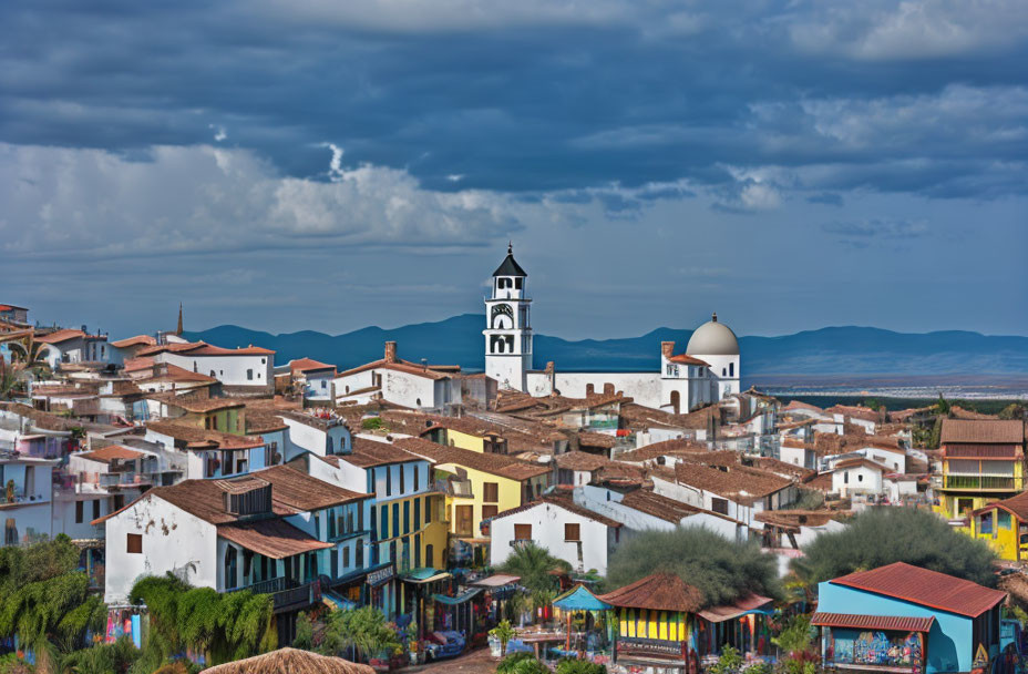 Quaint town with white buildings and bell tower under dramatic sky