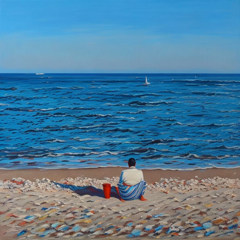 Person in towel on sandy beach gazes at blue sea with boats and red bucket.