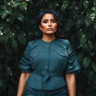 Victorian-inspired woman in high-collared blouse with floral hair decor.