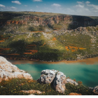 Tranquil rural landscape with lake, hills, farmhouses, and fields