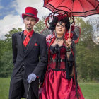 Victorian-style Couple in Elaborate Costumes Under Cloudy Sky