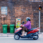 Vibrant street scene with scooters, colorful buildings, and lush flowers