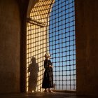 Animated characters in royal attire by ornate arched window at sunset