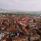 Vibrant hillside town with colorful houses, church spires, and misty mountains