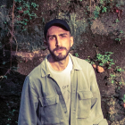 Man with Beard in Pastel Shirt Against Tropical Backdrop