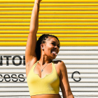 Colorful illustration: Smiling woman with raised fist on yellow backdrop