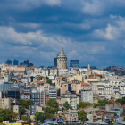 Quaint town with white buildings and bell tower under dramatic sky