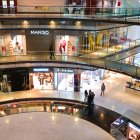 Ornate multi-level shopping arcade with Christmas decorations and snow-covered bustling atmosphere