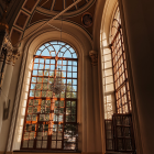 Gothic cathedral interior with tall stained glass windows and ornate arches