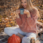 Woman in Pink Blouse Sitting Among Flowers with Teapot and Cup