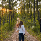 Woman walking on psychedelic forest path with lantern