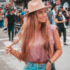 Stylish woman in cowboy hat and satin blouse in outdoor scene